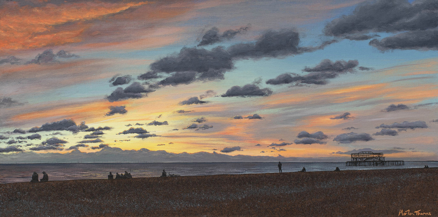 Painting by Martin Thomas of a Sunset over Brighton beach with people and the West pier, featuring warm colors and soft lighting.