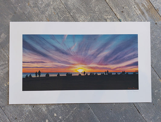 Art print of a sunset scene in Brighton with silhouettes on a wooden surface